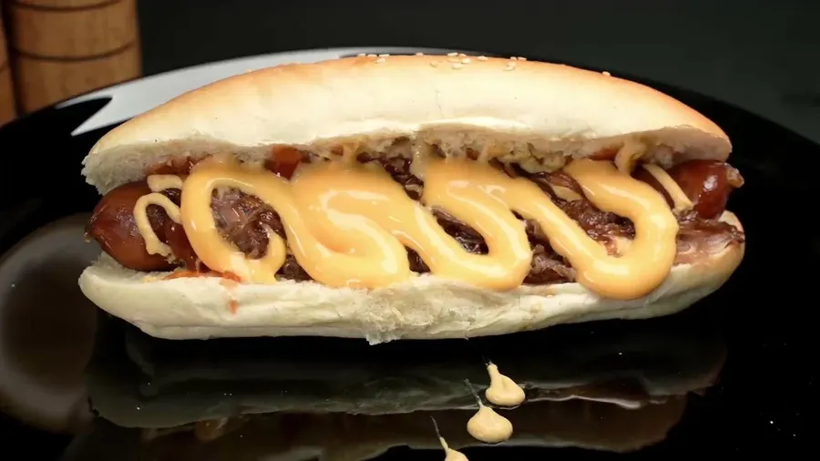 Hot dog cu sos de cheddar și ceapă caramelizată